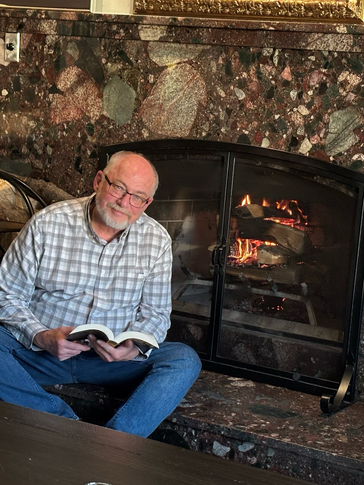 Mike Kent, journalist and author, reading by the fireplace