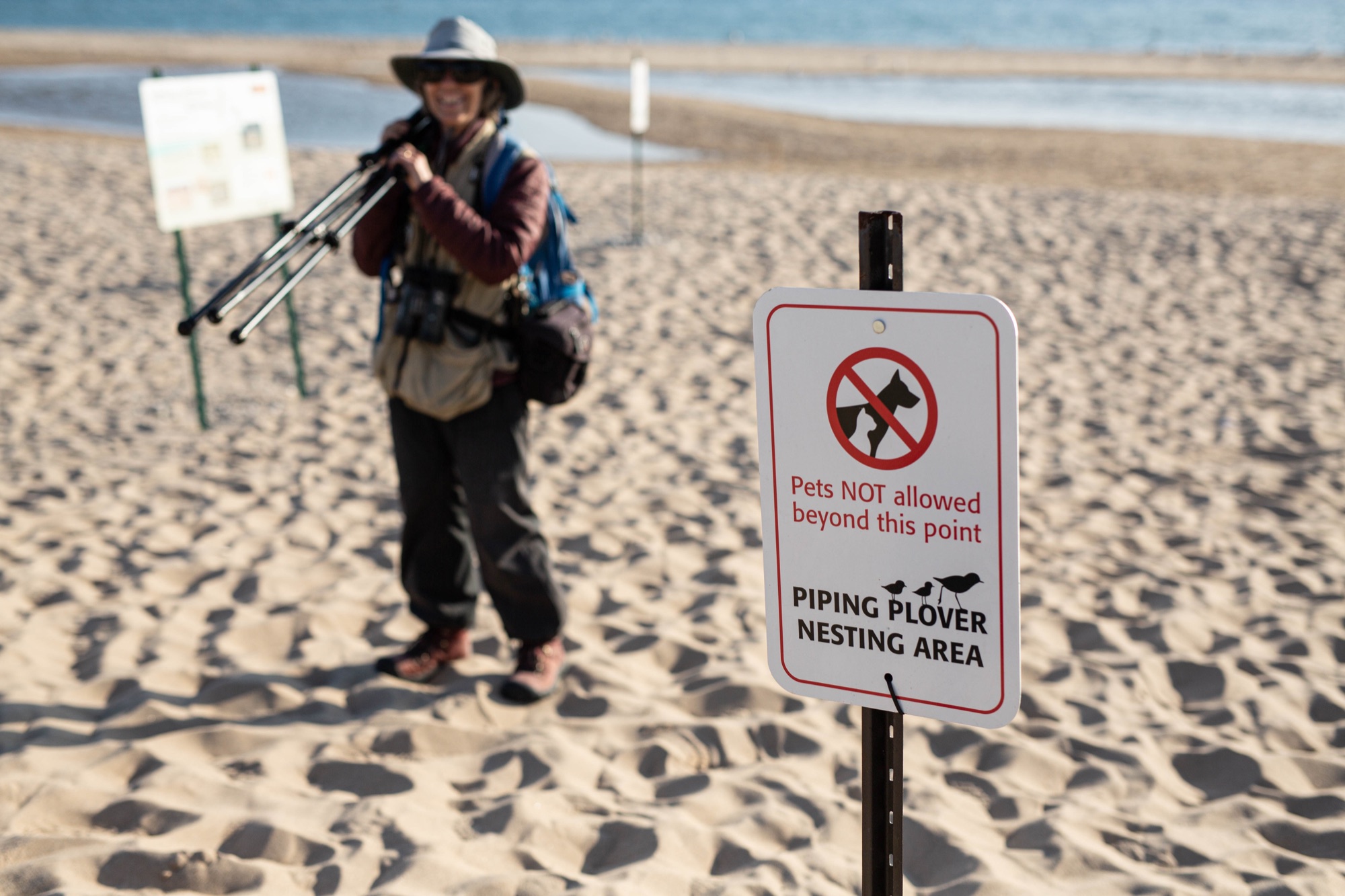 Alice Van Zoeren with her spotting scope on the beach at Sleeping Bear Dunes